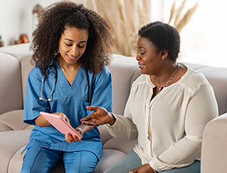 Younger nurse showing older woman medical charts