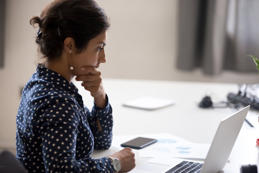 Concentrated entrepreneur analyzing metrics on a laptop