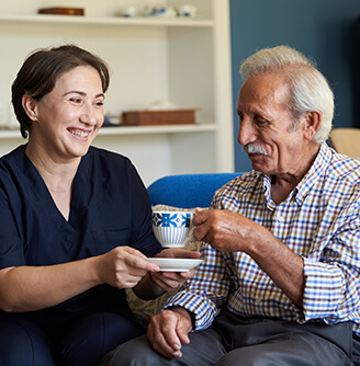 Home nurse and older man drinking tea